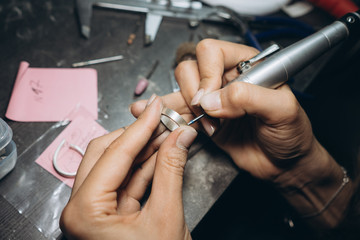 girl master processes the metal plate in the home workshop