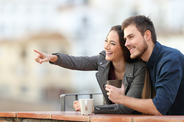 Sticker - Happy couple pointing away in a balcony