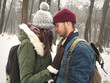 © sonyachny - Happy hipster couple in stylish outfits embracing and hugging in snowy winter park. Cute family taking selfie. Atmospheric cozy winter moments. Moody image
