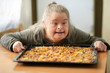 © muro - portrait of adult woman with down syndrome holding pizza