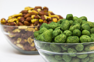 Roasted peanuts in glass bowl on white background