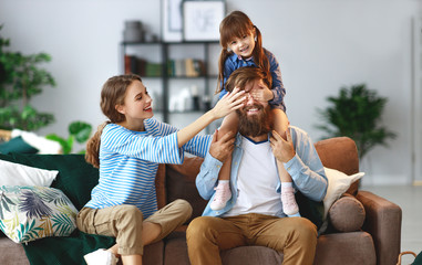 Wall Mural - happy family mother father and child daughter at home on couch