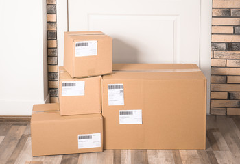 Poster - Cardboard parcel boxes on floor near apartment entrance. Mockup for design