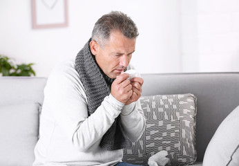 Wall Mural - Man suffering from cough and cold on sofa at home