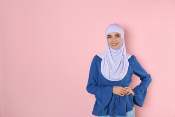 Canvas Print - Portrait of young Muslim woman in hijab against color background. Space for text