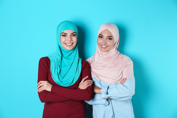 Canvas Print - Portrait of young Muslim women in hijabs against color background