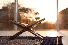 Rehal With Open Quran On Muslim Prayer Rug Indoors