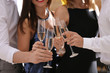 © New Africa - Friends clinking glasses with champagne at party, closeup