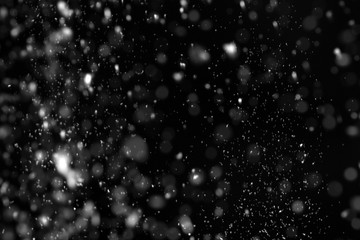 Snow flakes falling on black background. Winter weather