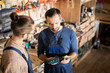 © Seventyfour - High angle portrait of mature carpenter training  apprentice standing in modern woodworking shop, copy space