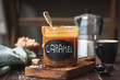 Homemade salted caramel sauce in a jar at the kitchen counter