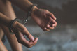 © Tinnakorn - close-up of hands in handcuff,  Female prisoner, Arrested woman handcuffed hands. Prisoner or arrested terrorist, hacker, bribetaker.