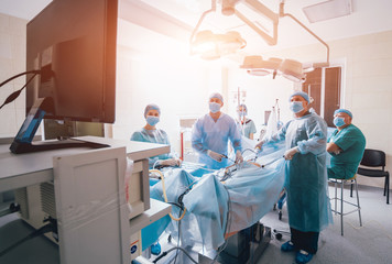 Wall Mural - Process of gynecological surgery operation using laparoscopic equipment. Group of surgeons in operating room with surgery equipment