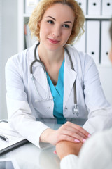 Wall Mural - Doctor woman looking at  patient while speaking to her and reassuring. Medicine, healthcare and help concept 