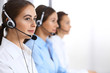 © rogerphoto - Call center. Group of operators at work. Focus at beautiful business woman in headset