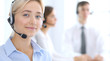 © rogerphoto - Call center. Group of operators at work. Focus at blonde business woman in headset