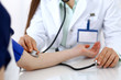 © rogerphoto - Doctor woman checking blood pressure of female patient, close-up. Cardiology in medicine  and health care concept