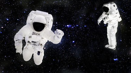 Poster - Astronauts in spacesuits floating in outer space. Spacemans at work. Starry dust. Elements of this image furnished by NASA