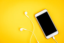 Mobile Phone And Headphones On Yellow Background