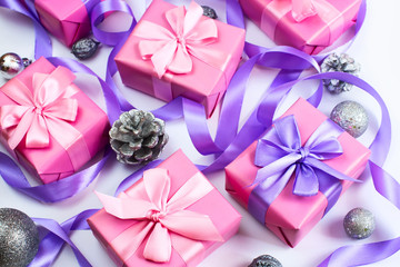 Christmas boxes with gifts on the occasion of pink color on white background cones nuts decor Top view flat lay horizontal Selective focus