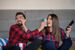 © FS-Stock - Couple fighting for remote control while watching TV at home