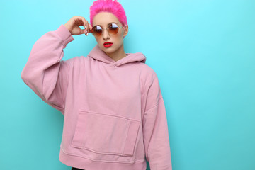 Wall Mural - Fashion portrait of young hipster woman in pink hoody. Short pink hair