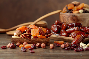 Various dried fruits and nuts in wooden dish.