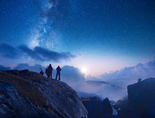 Group Of Travelers Looking At The Starry Sky In The Mountains