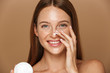© Drobot Dean - Beauty image of attractive shirtless woman smiling and holding jar with face cream, isolated over beige background