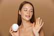 © Drobot Dean - Beauty image of pleased shirtless woman smiling and holding jar with face cream, isolated over beige background