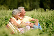 © aletia2011 - Portrait of nice mature couple sitting on green grass in summer park