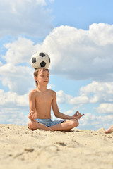 Poster - Portrait of boy with ball on beach in summer day