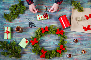 Wall Mural - On the wooden table, womans hands make a crown for the festive season