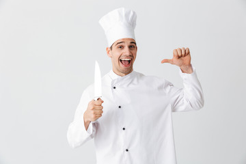 Wall Mural - Happy chef cook wearing uniform holding a knife