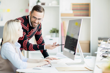 cheerful hipster programming colleagues discussing app development: smiling handsome man giving advi