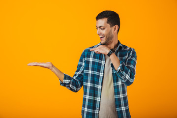 Cheerful young man wearing plaid shirt standing