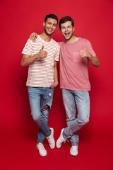 Canvas Print - Two cheerful men friends standing isolated over red