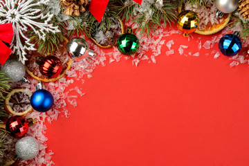 Christmas and New Year frame for text with a Christmas tree and colored Christmas decorations on a red bright background. view from above.