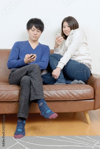 ソファに座ってスマホを見るカップル Stock Photo Adobe Stock