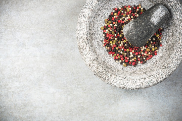 Wall Mural - Mixed peppercorn seeds in granite pestle or mortar