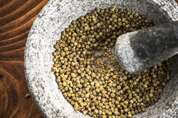 Wall Mural - Green peppercorn seed in granite mortar or pestle