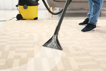 Poster - Man removing dirt from carpet with vacuum cleaner in room