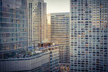 Wall Mural - Vintage tone image dense skyline along Chicago river at sunset, modern illuminated skyscrapers in downtown