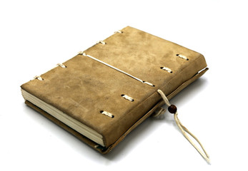 Handcrafted leather notebook with a cord closing system.Isolated on white background. Worn vintage aspect.Copy space, Room for text.