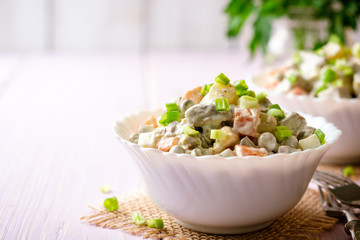 Wall Mural - Traditional Russian salad Olivier in bowls on wooden table. Selective focus.