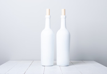 Wall Mural - Red wine bottle on a white wooden background