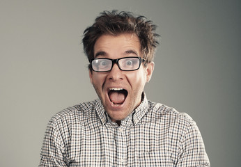 Wall Mural - Young man with glasses opened his mouth in surprise