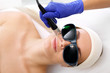 Fotoodmładzanie za pomocą lasera. Kobieta w salonie kosmetycznym podczas zabiegu z użyciem lasera.