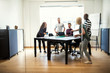 © Flamingo Images - Young designers playing table tennis inside of an office boardro