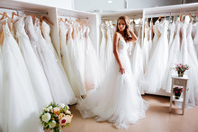 Back View Of A Young Woman In Wedding Dress Looking At Bridal Gowns On Display In Boutique
